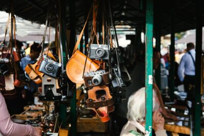 people standing near store and different cameras hanging